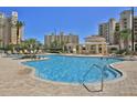 Resort-style pool area with comfortable lounge chairs and inviting clear blue water at 265 Minorca Beach Way # 505, New Smyrna Beach, FL 32169