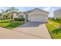 Welcoming home with a wide driveway, lush lawn, a palm tree, and tasteful landscaping at 2943 Gibraltar Blvd, New Smyrna Beach, FL 32168