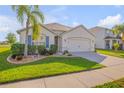 Inviting home with vibrant green lawn, mature landscaping, and a bench under a palm tree at 2943 Gibraltar Blvd, New Smyrna Beach, FL 32168