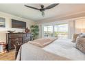 Bright bedroom with balcony, ceiling fan, dresser, and warm, neutral tones at 315 N Causeway # C402, New Smyrna Beach, FL 32169