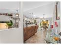 Bright open-concept space featuring wood flooring, a comfortable sofa, and seamless flow to the dining and kitchen areas at 3403 Kumquat Dr, Edgewater, FL 32141