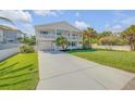 Inviting two-story beach home featuring double balconies, a pristine lawn, and a spacious driveway at 4624 Van Kleeck Dr, New Smyrna Beach, FL 32169