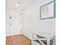 Bright hallway with a white front door, stylish mirror, and a charming white bench at 5300 S Atlantic Ave # 3-301, New Smyrna Beach, FL 32169