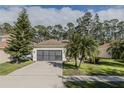 Single-story house featuring a well-maintained lawn and a two-car garage at 5424 Frederick Lake Dr, Port Orange, FL 32128