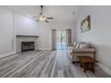 Cozy living room with a fireplace, wood floors, and neutral-toned furniture at 5424 Frederick Lake Dr, Port Orange, FL 32128