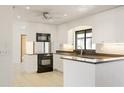 Bright kitchen with black appliances, white cabinets, and ample countertop space at 55 Bay Harbour Dr, Ponce Inlet, FL 32127