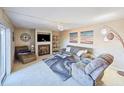 Cozy living room featuring a comfortable sofa, fireplace, ceiling fan, and sliding door to the outside at 61 Cedar Dunes Dr, New Smyrna Beach, FL 32169