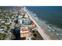 Stunning aerial view of a beachfront condo complex, nestled along a pristine shoreline with ocean views at 701 S Atlantic Ave # 11, New Smyrna Beach, FL 32169