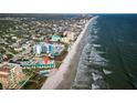 Stunning aerial view of beachfront property with ocean views and a community pool, perfect for coastal living at 701 S Atlantic Ave # 11, New Smyrna Beach, FL 32169