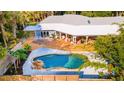 Aerial view showcasing backyard oasis with pool, wooden deck, covered patio, and privacy fence at 725 Ingham Rd, New Smyrna Beach, FL 32168