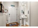 Bright powder room with pedestal sink, decorative mirror, and stylish beach themed decor at 94 Bella Vita Way, Ormond Beach, FL 32174
