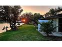 Beautiful sunset view overlooking a lush green lawn and tranquil lake at 108 Lake Fairgreen Cir, New Smyrna Beach, FL 32168