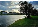 Scenic water view with lush green landscaping and a tranquil and serene atmosphere at sunset at 108 Lake Fairgreen Cir, New Smyrna Beach, FL 32168