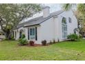 White two-story home featuring manicured landscaping, arched windows, and a gray roof at 111 Esther St, New Smyrna Beach, FL 32169