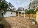 Spacious brick paved backyard with a pergola and storage shed at 1208 Pat Ave, New Smyrna Beach, FL 32168