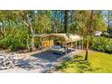 Covered carport provides shelter for your vehicle and equipment, surrounded by lush greenery at 1370 Jane Lacey Ln, New Smyrna Beach, FL 32168