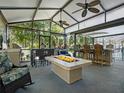 Covered outdoor patio area with fire pit, ceiling fans, bar and grill, and lounge seating at 1370 Jane Lacey Ln, New Smyrna Beach, FL 32168