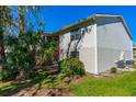 Corner of home with screened porch, lush landscaping, and a well-maintained lawn under a blue sky at 1600 Big Tree Rd # I2, South Daytona, FL 32119