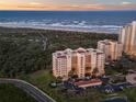 Stunning aerial view of the condo complex near the beach, showcasing its proximity to the ocean at 261 Minorca Beach Way # 606, New Smyrna Beach, FL 32169
