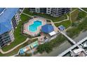 Aerial view of the community pool, lounge chairs, and dock with colorful kayaks at 2700 N Peninsula Ave # 113, New Smyrna Beach, FL 32169
