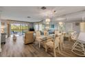 Open concept dining and living area features a mirrored wall, chandelier, and glass dining table at 2700 N Peninsula Ave # 513, New Smyrna Beach, FL 32169