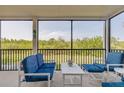 Enclosed back patio offers views of mature trees, black railings, and comfortable seating at 2700 N Peninsula Ave # 513, New Smyrna Beach, FL 32169