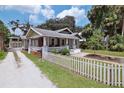 Inviting home with a well-maintained lawn, picket fence, and a charming front porch at 303 Washington St, New Smyrna Beach, FL 32168