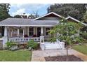 Charming home with a cozy front porch, classic columns, and lush landscaping at 303 Washington St, New Smyrna Beach, FL 32168