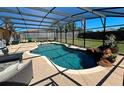 Inviting in-ground pool with a screened enclosure, rock feature, and ample space for outdoor seating at 3163 Dudley Dr, Deltona, FL 32738