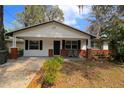 Inviting single-story home showcasing a neat front yard with a cozy seating area on the porch at 349 Fletcher Ave, Daytona Beach, FL 32114