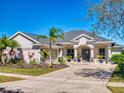 Charming front exterior featuring a well-manicured lawn, mature trees, and an inviting entrance at 3611 Marisol Ct, New Smyrna Beach, FL 32168