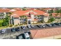 Inviting condo complex with beautiful landscaping, terracotta roof, and convenient parking spaces at 407 Bouchelle Dr # 205, New Smyrna Beach, FL 32169