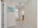 Hallway view of kitchen, entryway and the living room with white tiled floors and neutral wall paint at 407 Bouchelle Dr # 205, New Smyrna Beach, FL 32169