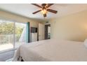 Comfortable main bedroom with ceiling fan, walk-out to private porch, and ensuite at 4150 S Atlantic Ave # 119C, New Smyrna Beach, FL 32169