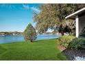 Scenic view of the lake with a lush green lawn and mature trees at 549 Coral Trace Blvd, Edgewater, FL 32132