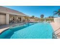 A sparkling community pool surrounded by lounge chairs and a covered patio area at 549 Coral Trace Blvd, Edgewater, FL 32132