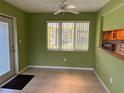 Bright dining room with tile floors, a ceiling fan, and natural light from a large window at 630 Yupon Ave, New Smyrna Beach, FL 32169