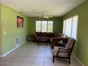 Comfortable living room featuring tile flooring, a ceiling fan, and ample seating at 630 Yupon Ave, New Smyrna Beach, FL 32169