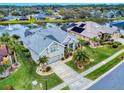 An aerial view of a single-story home with a lake view, landscaped yard, and screened lanai with pool at 6665 Merryvale Ln, Port Orange, FL 32128