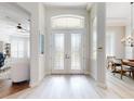 Bright foyer features white double doors with decorative glass and light wood-look flooring throughout at 6665 Merryvale Ln, Port Orange, FL 32128
