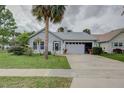 Charming single-story home features an attached garage, landscaped front yard, and mature palm trees enhancing curb appeal at 731 Pine Shores Cir, New Smyrna Beach, FL 32168