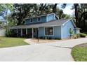 Charming home features blue siding, a well-manicured lawn, and a paved driveway leading to an attached garage at 855 Sugar House Dr, Port Orange, FL 32129
