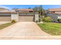 Townhome featuring an attached garage and quaint landscaping at 210 Pine Cone Trl, Ormond Beach, FL 32174