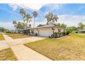 Charming home featuring an attached garage, well-maintained lawn and landscaping at 222 Brittany Ave, Port Orange, FL 32127