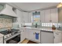 This kitchen features modern appliances, white cabinets and light tile backsplash at 312 Jefferson Ave, Port Orange, FL 32127