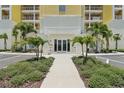 Welcoming entrance to building featuring manicured plants, flowers and paved walkway at 7 Riverwalk Dr # 206, New Smyrna Beach, FL 32169