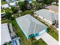 Aerial view of bright blue home with grey roof, nearby waterway, and neatly kept lawn at 113 Douglas St, Edgewater, FL 32141