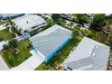 Birds-eye view of a turquoise house with a grey roof and a long driveway, close to the water at 113 Douglas St, Edgewater, FL 32141