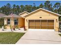 Charming yellow home featuring a well-manicured lawn, lovely landscaping and an inviting entrance at 1827 Palmetto Scrub Cir, Port Orange, FL 32128