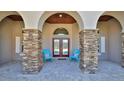Inviting front porch with stone columns and seating area for relaxing at 2904 Palma Ln, New Smyrna Beach, FL 32168